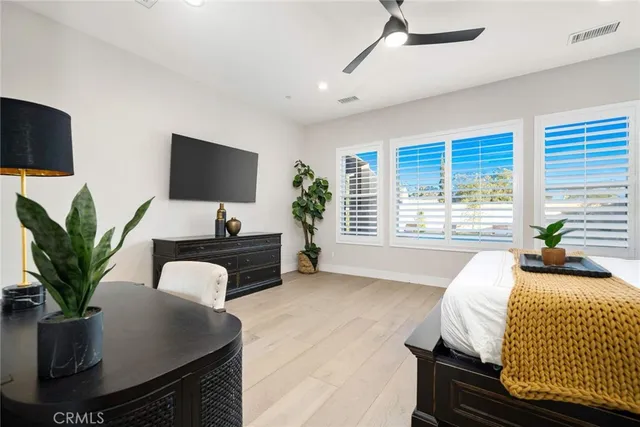 a bedroom with a large bed and a potted plant
