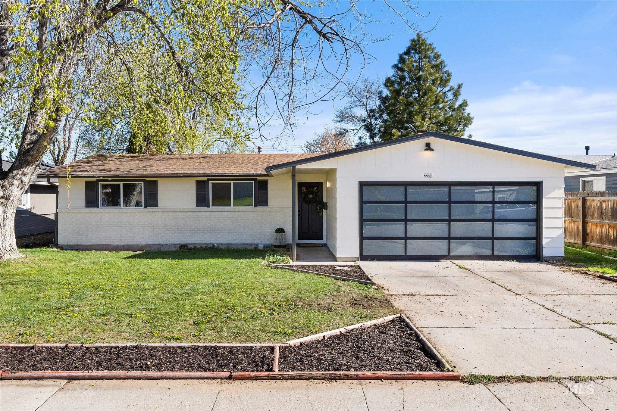 View of front of property with concrete driveway, brick siding, and an attached garage