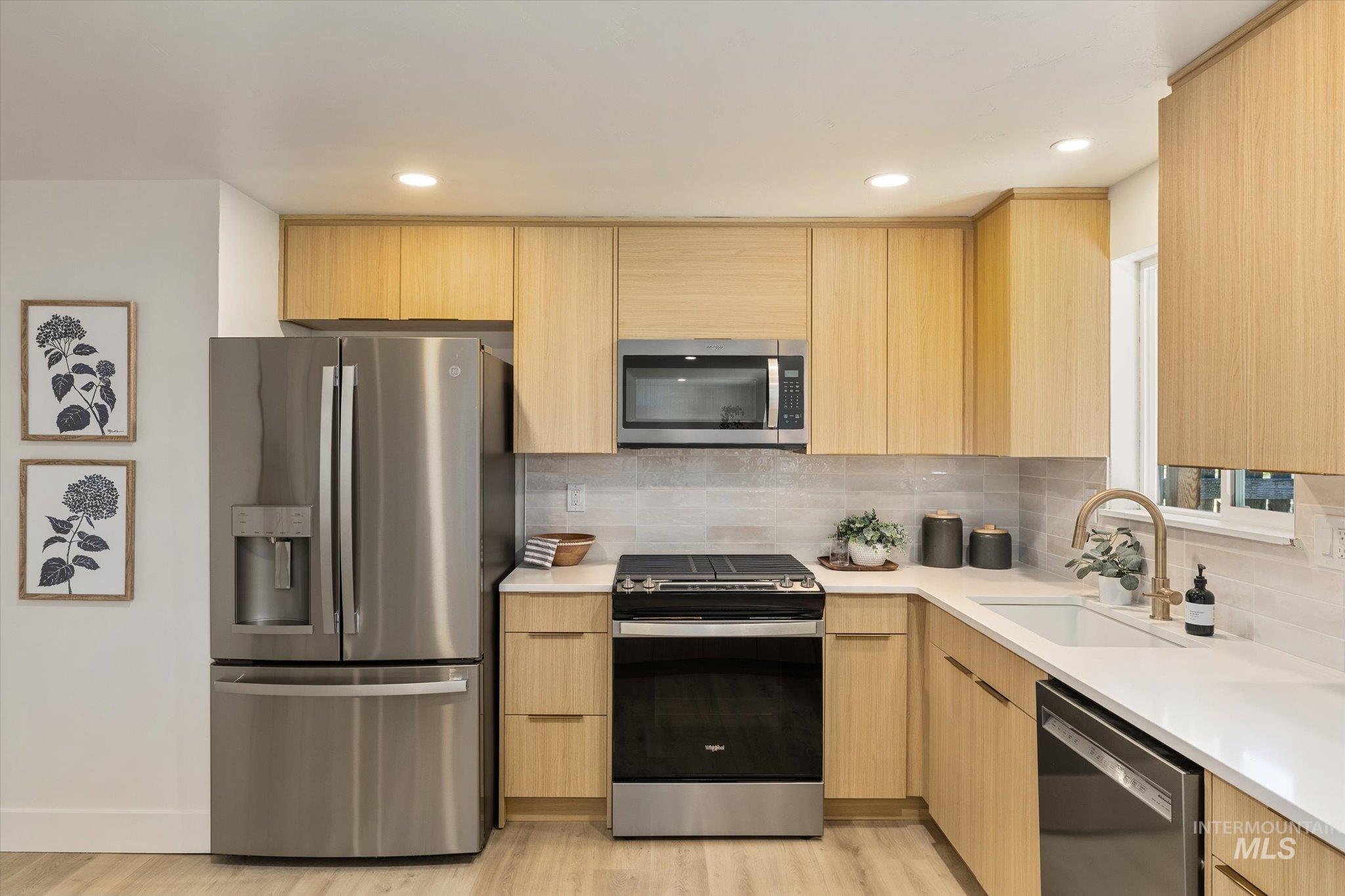 2220 Panama Street Boise, ID 83705 - Photo 11 of 27 Kitchen featuring stainless steel appliances, modern cabinets, light wood finished floors, light wood finish cabinetry, and light stone counters