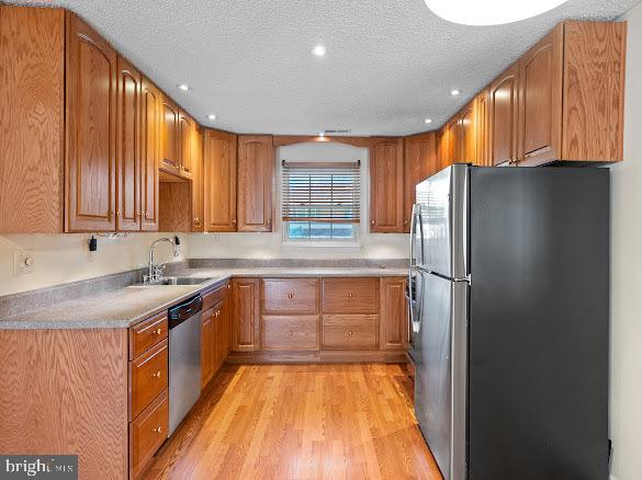 43 Via Cascata Drive Clementon, NJ 08021 - Photo 10 of 26 a kitchen with stainless steel appliances granite countertop a refrigerator a sink dishwasher and wooden cabinets with wooden floor