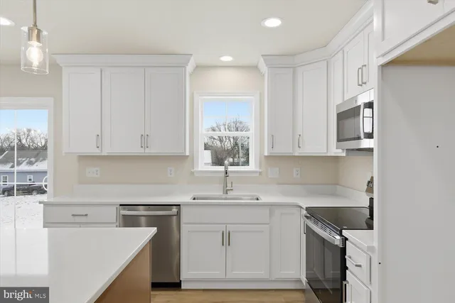 a kitchen with cabinets appliances a sink and a counter top space