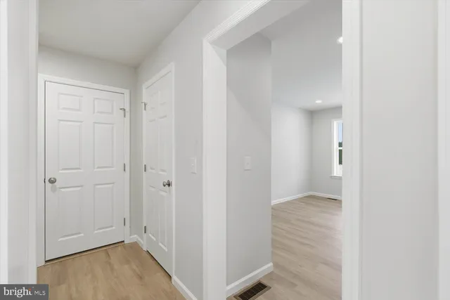 a view of a hallway with wooden floor