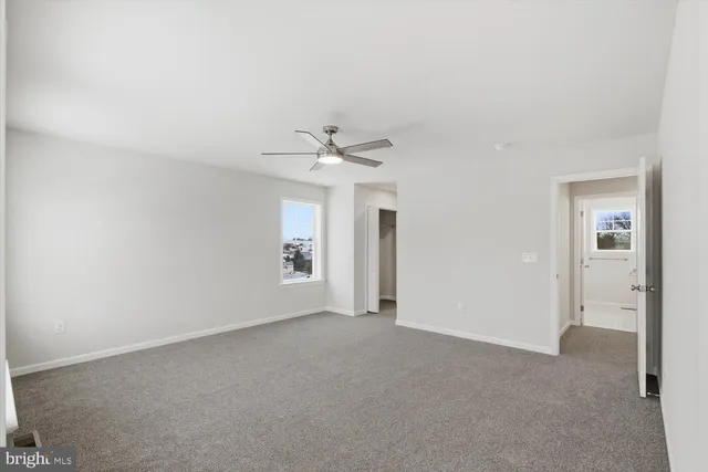 a view of a big room with windows and chandelier fan