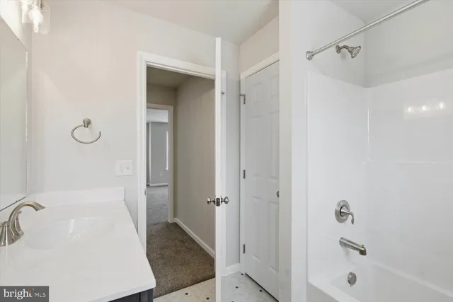 a bathroom with a granite countertop sink a mirror and shower