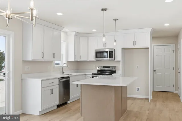 a kitchen with white cabinets and refrigerator