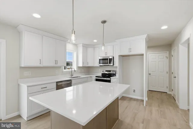 a large kitchen with stainless steel appliances granite countertop a sink a stove and a refrigerator