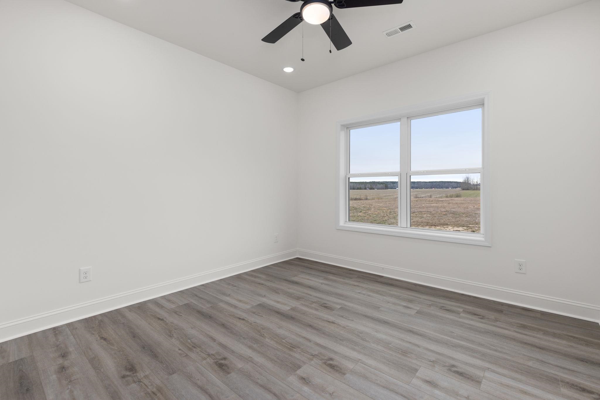 460 County Road 514 Rienzi, MS 38865 - Photo 13 of 29 an empty room with wooden floor fan and windows