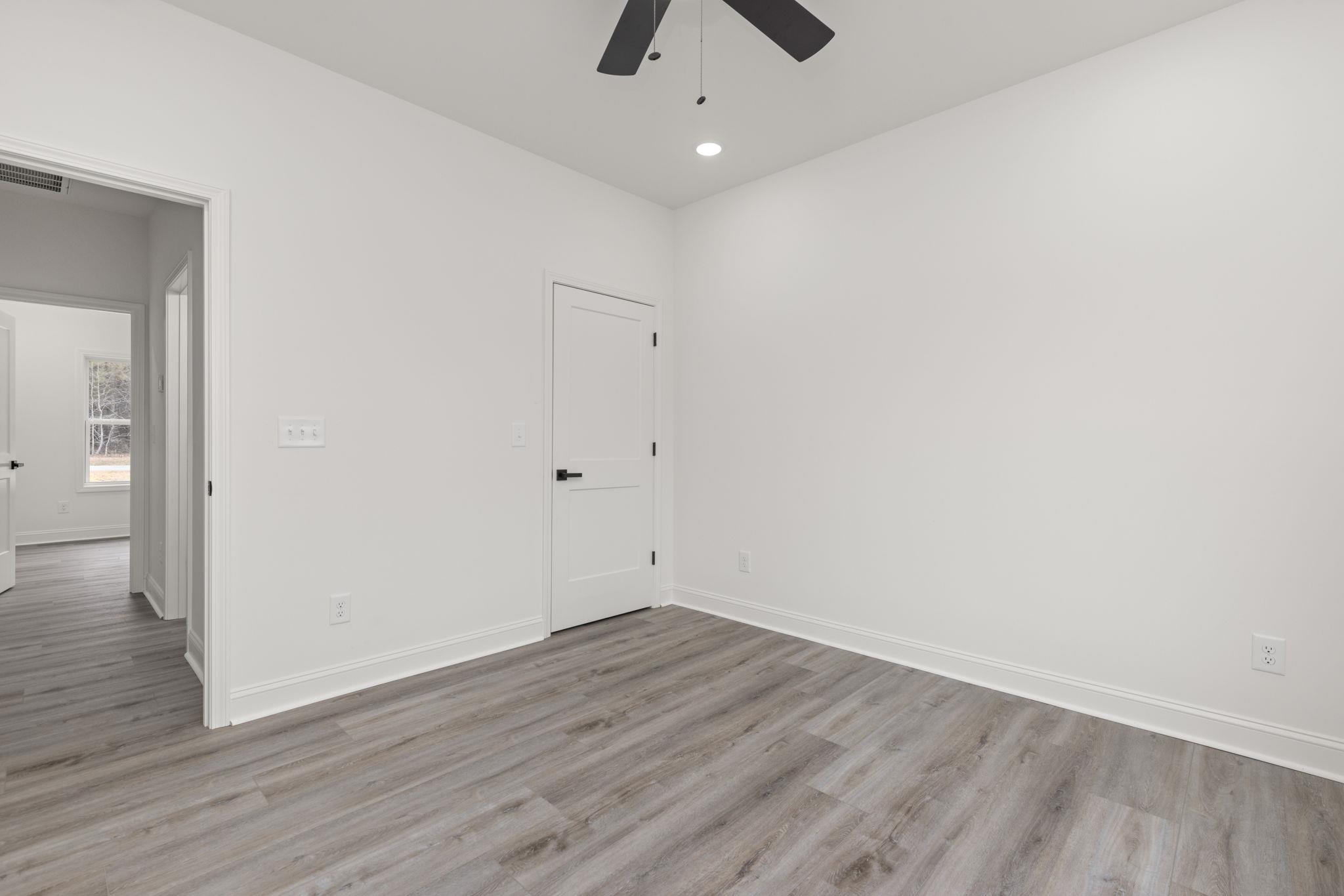 460 County Road 514 Rienzi, MS 38865 - Photo 14 of 29 an empty room with wooden floor and ceiling fan