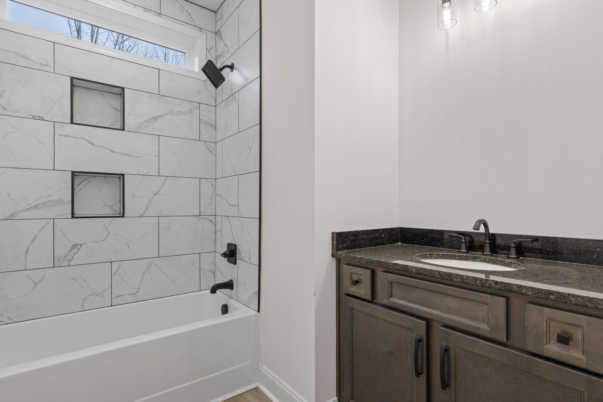 460 County Road 514 Rienzi, MS 38865 - Photo 17 of 29 a bathroom with a granite countertop sink a toilet and bathtub