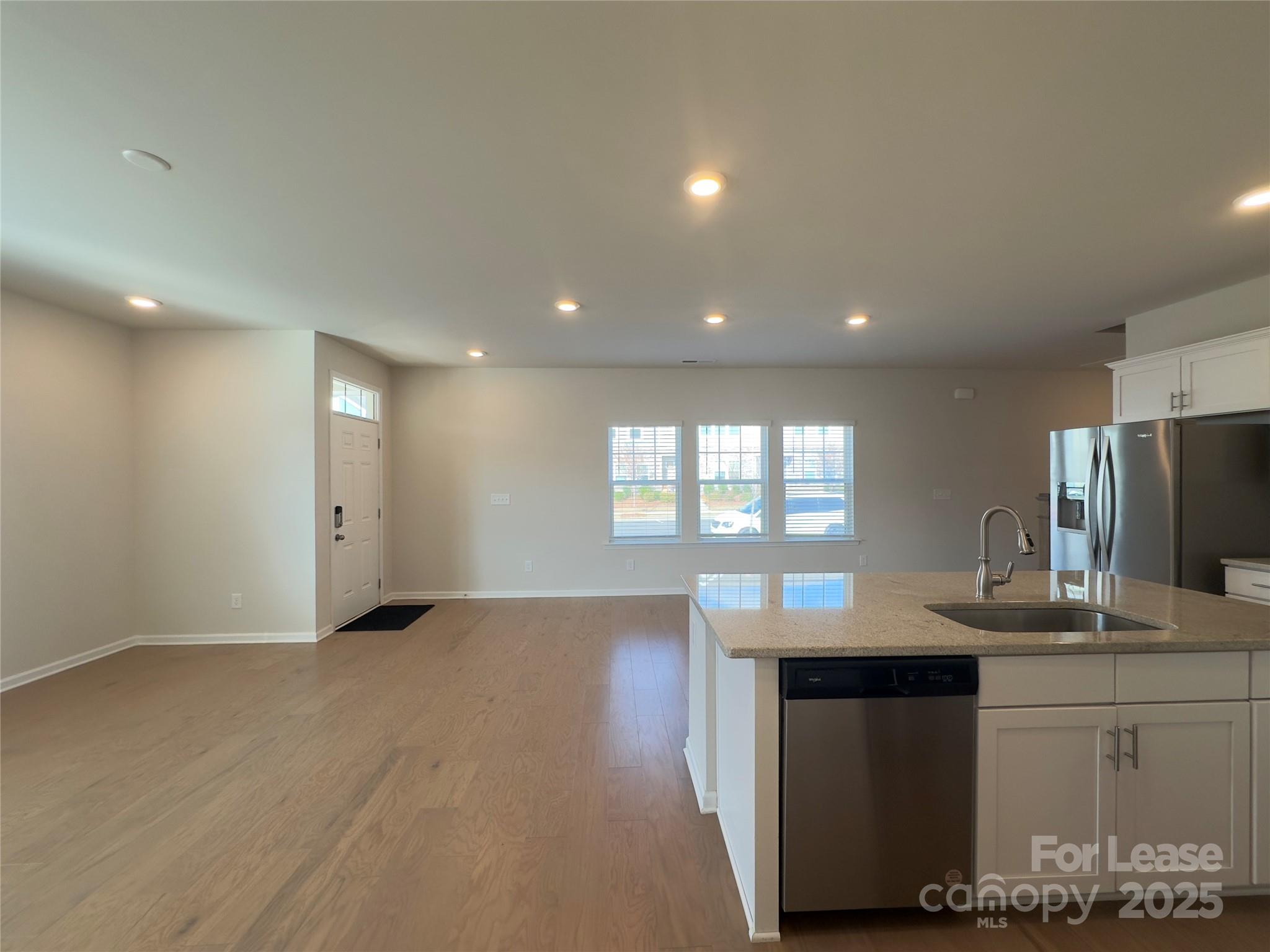 403 Wescott Street, Unit 68 Indian Trail, NC 28079 - Photo 6 of 42 a kitchen with kitchen island granite countertop a sink and wooden floors