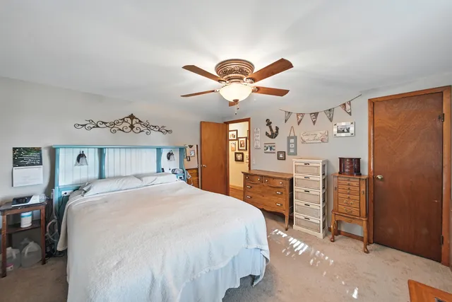 a spacious bedroom with a bed and a chandelier