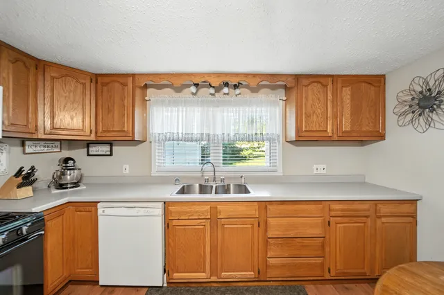 a kitchen with stainless steel appliances granite countertop a sink stove and cabinets