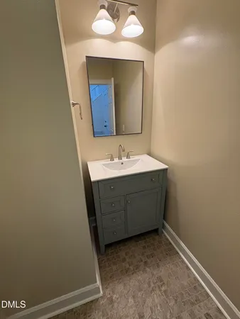 a room with a sink vanity and mirror