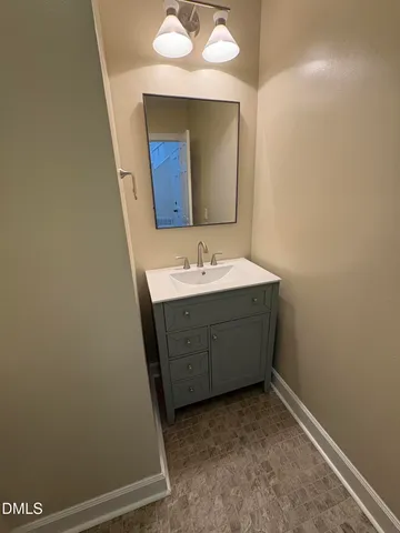 a room with a sink vanity and mirror