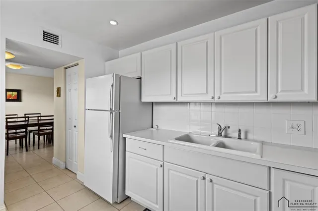 a kitchen with appliances a sink and cabinets