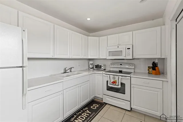 a kitchen with white cabinets and white appliances