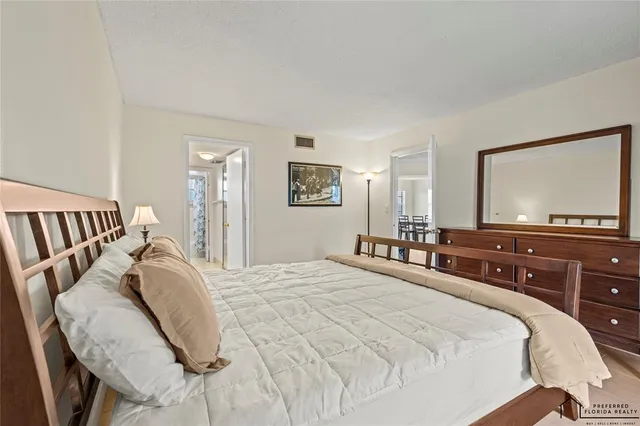 a bedroom with a large bed and a flat tv screen on dresser