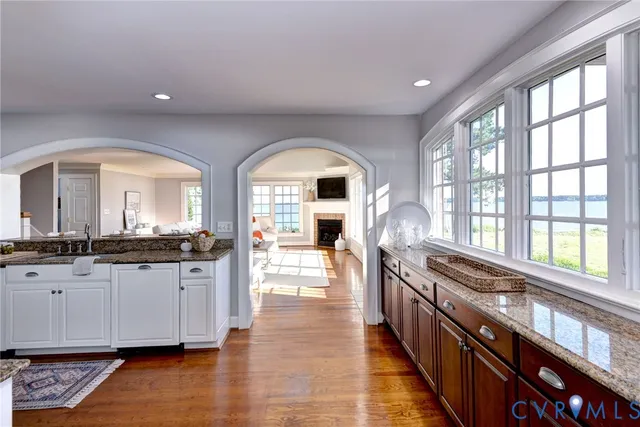 a view of a kitchen with granite countertop a large window and stainless steel appliances