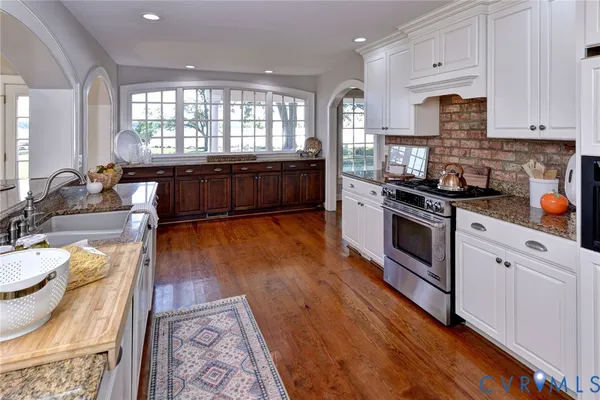 a kitchen with stainless steel appliances granite countertop a stove a sink and a microwave