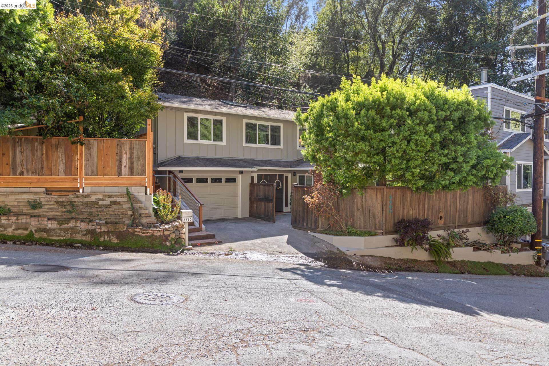 6660 Sobrante Road Oakland, CA 94611 - Photo 46 of 48 Two-story residence featuring a two-car garage, terraced landscaping, and a fenced perimeter