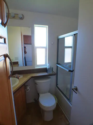 a bathroom with a granite countertop toilet sink and mirror