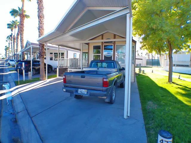 a front view of a house with swimming pool table and chairs