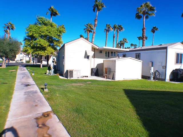 a view of a white house with a yard and potted plants
