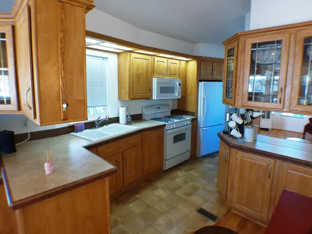 a kitchen with stainless steel appliances granite countertop a sink a stove and a refrigerator