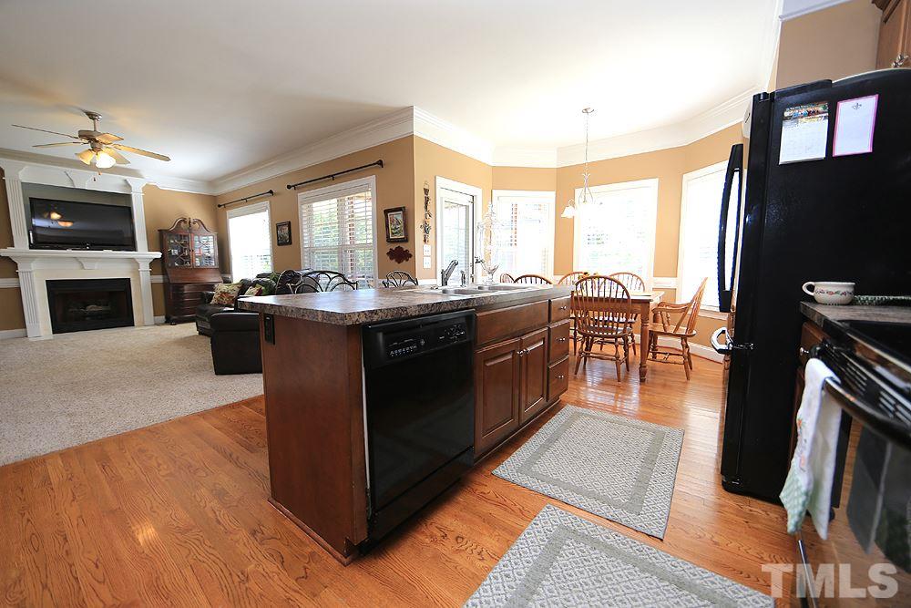 214 Steve Ridge Willow Spring, NC 27592 - Photo 11 of 29 a living room with stainless steel appliances granite countertop furniture a fireplace a flat screen tv and a large window