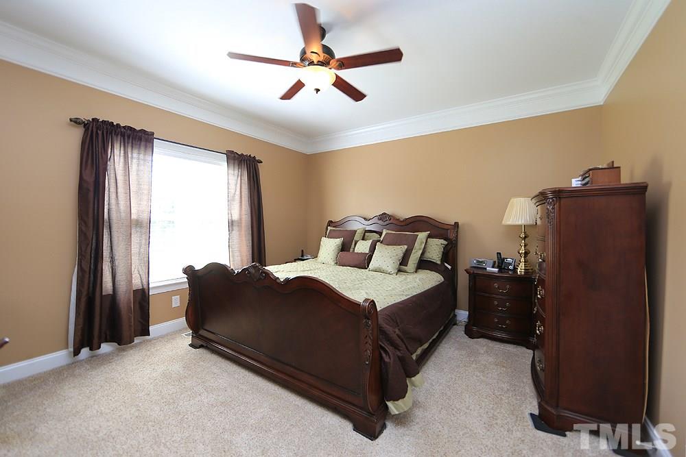 214 Steve Ridge Willow Spring, NC 27592 - Photo 15 of 29 a bedroom with a bed and a ceiling fan