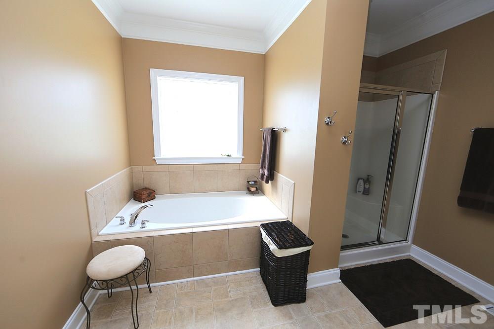 214 Steve Ridge Willow Spring, NC 27592 - Photo 17 of 29 a bathroom with a tub sink and a mirror
