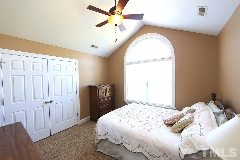 214 Steve Ridge Willow Spring, NC 27592 - Photo 19 of 29 a bedroom with a bed and a chandelier
