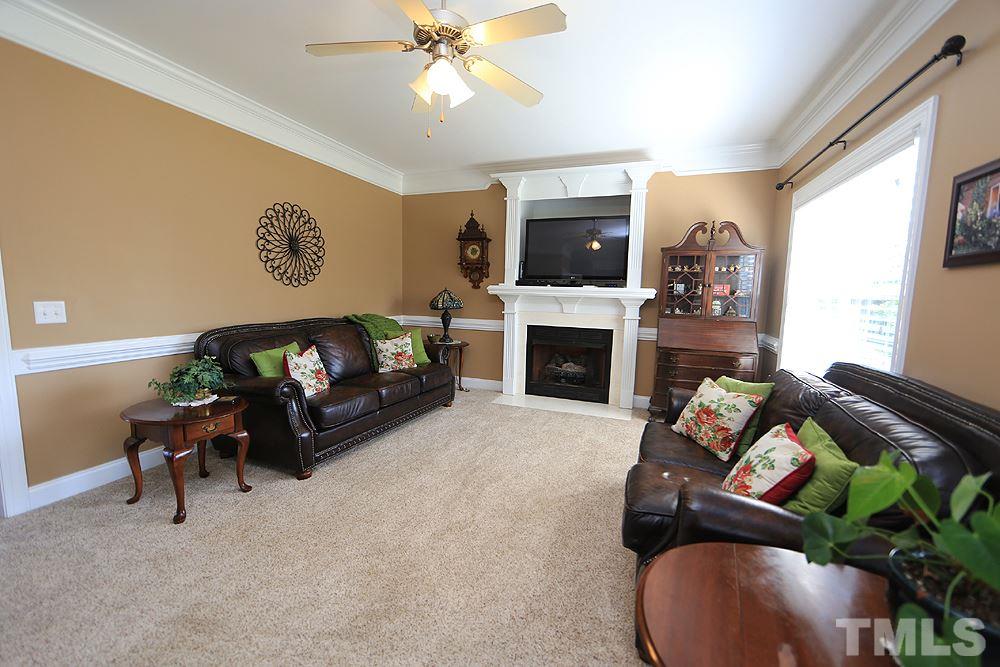 214 Steve Ridge Willow Spring, NC 27592 - Photo 7 of 29 a living room with furniture a flat screen tv and a fireplace