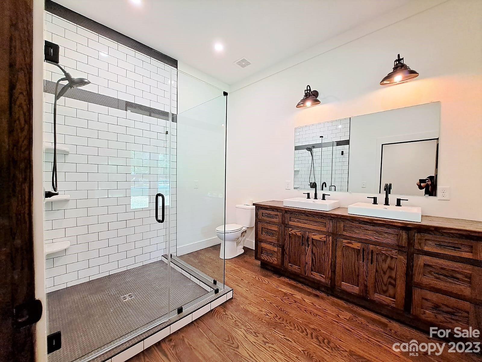 a spacious bathroom with double vanity and a shower
