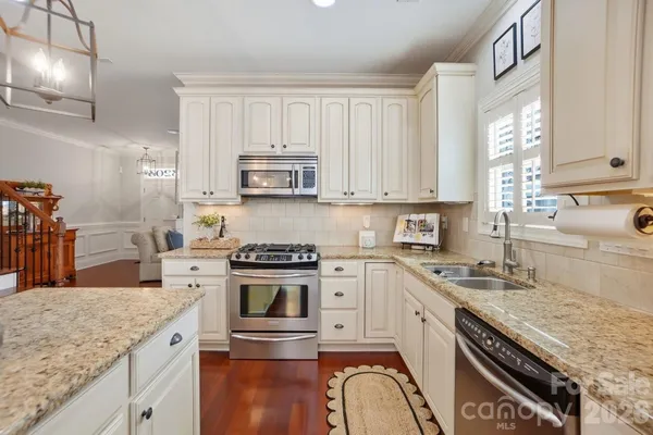 a kitchen with granite countertop white cabinets and white appliances