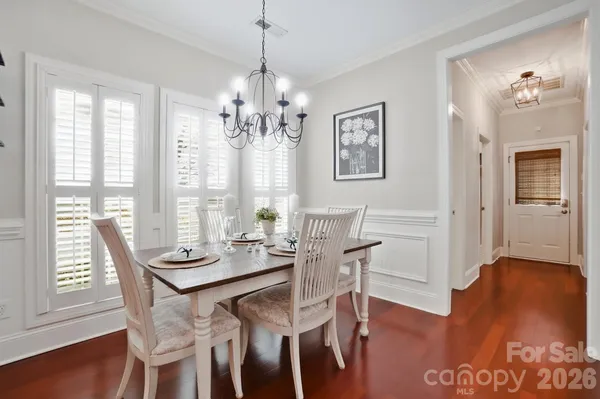a dining room with kitchen island stainless steel appliances furniture a large window and kitchen view
