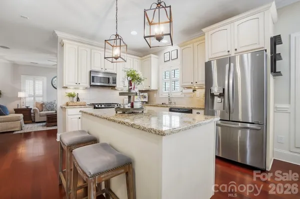a kitchen with granite countertop a sink cabinets and stainless steel appliances