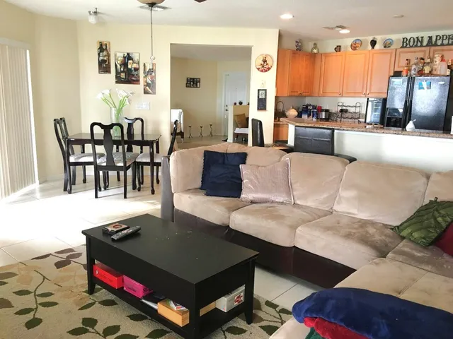 a living room with furniture and a dining table