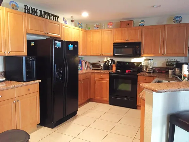 a kitchen with stainless steel appliances a refrigerator a stove a sink and a microwave