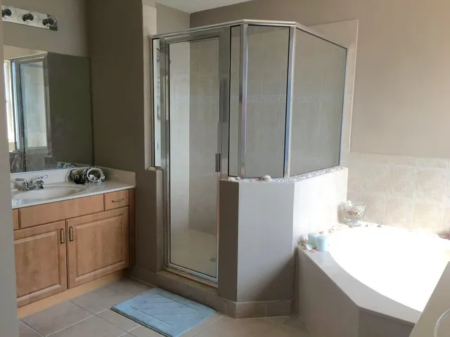 a bathroom with a tub sink and mirror