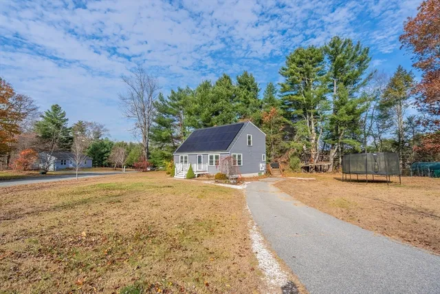 a front view of a house with a yard and trees