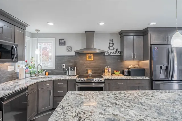 a kitchen with stainless steel appliances granite countertop a refrigerator stove and sink