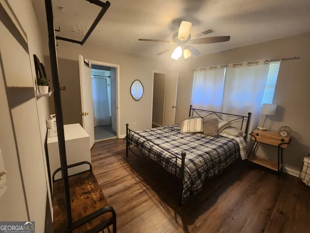 a bedroom with a bed and a mirror on the dresser