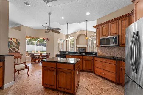a large kitchen with granite countertop lots of counter space and stainless steel appliances