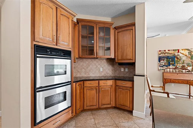 a kitchen with granite countertop white cabinets and stainless steel appliances