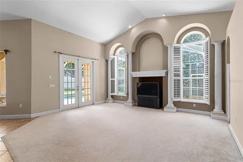 a view of an empty room with a fireplace and a window