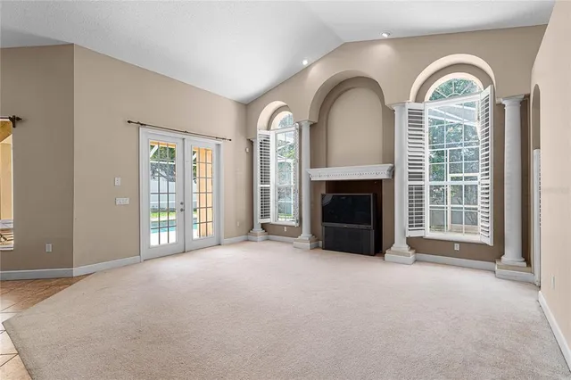 a view of an empty room with a fireplace and a window