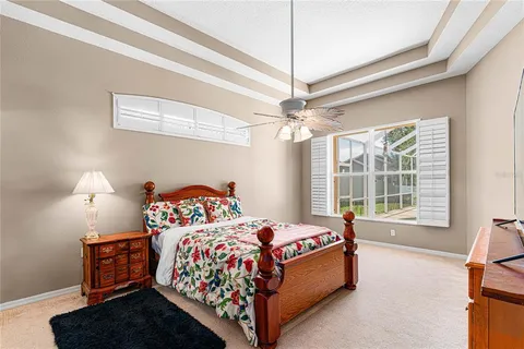 a bedroom with a bed chandelier and a window