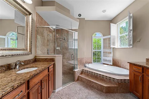 a spacious bathroom with a granite countertop tub sink and mirror