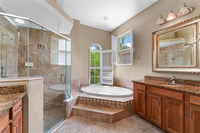 a spacious bathroom with a tub sink and mirror